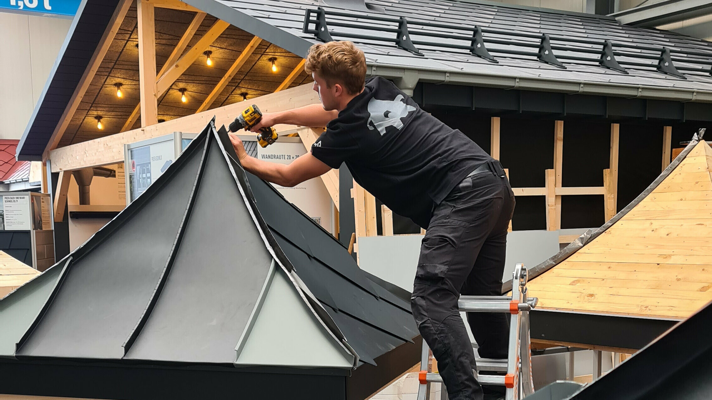 Ein Teilnehmer von der ersten deutschen Klempnermeisterschaft in Hamburg baut gerade an seinem PREFA Dachmodell.
