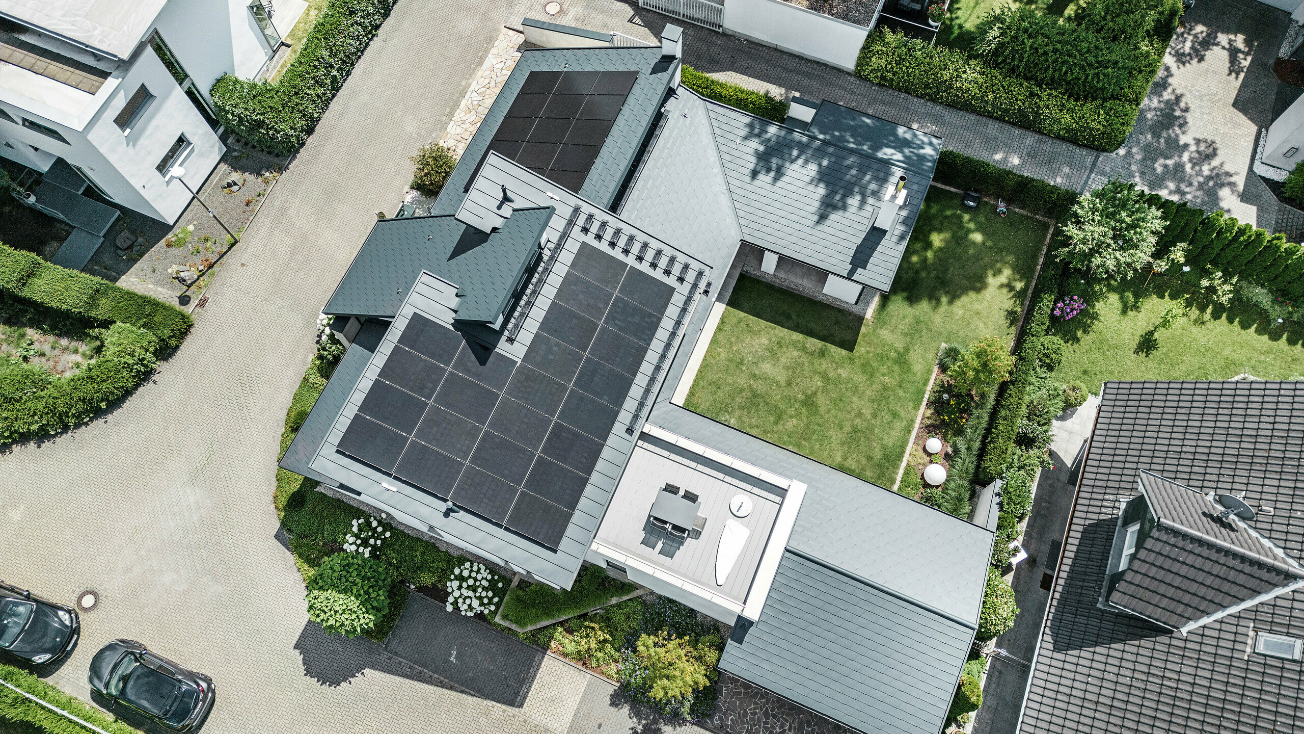 Drohnenaufnahme der außergewöhnlichen Dachlandschaft eines Einfamilienhauses in Dortmund mit einem PREFA Komplettsystem aus Aluminium und einer großflächigen Photovoltaikanlage