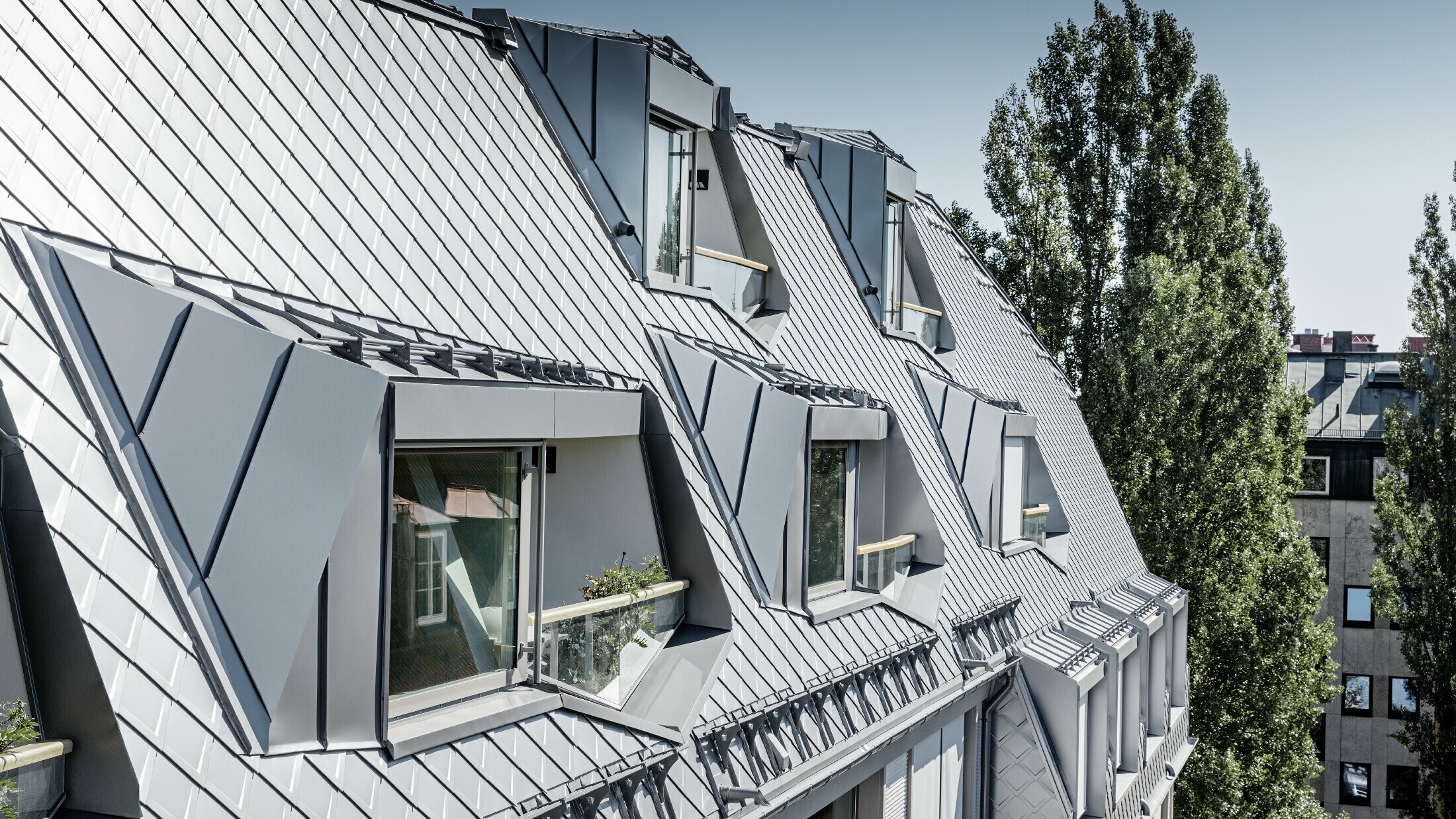 Sanierte Mansardenwohnungen mit großzügigen offenen Galerieebenen eines Wohn- und Geschäftshauses in der Leopoldstraße/Ecke Hohenzollernstraße in München, mit einer Dacheindeckung von PREFA - Dachraute