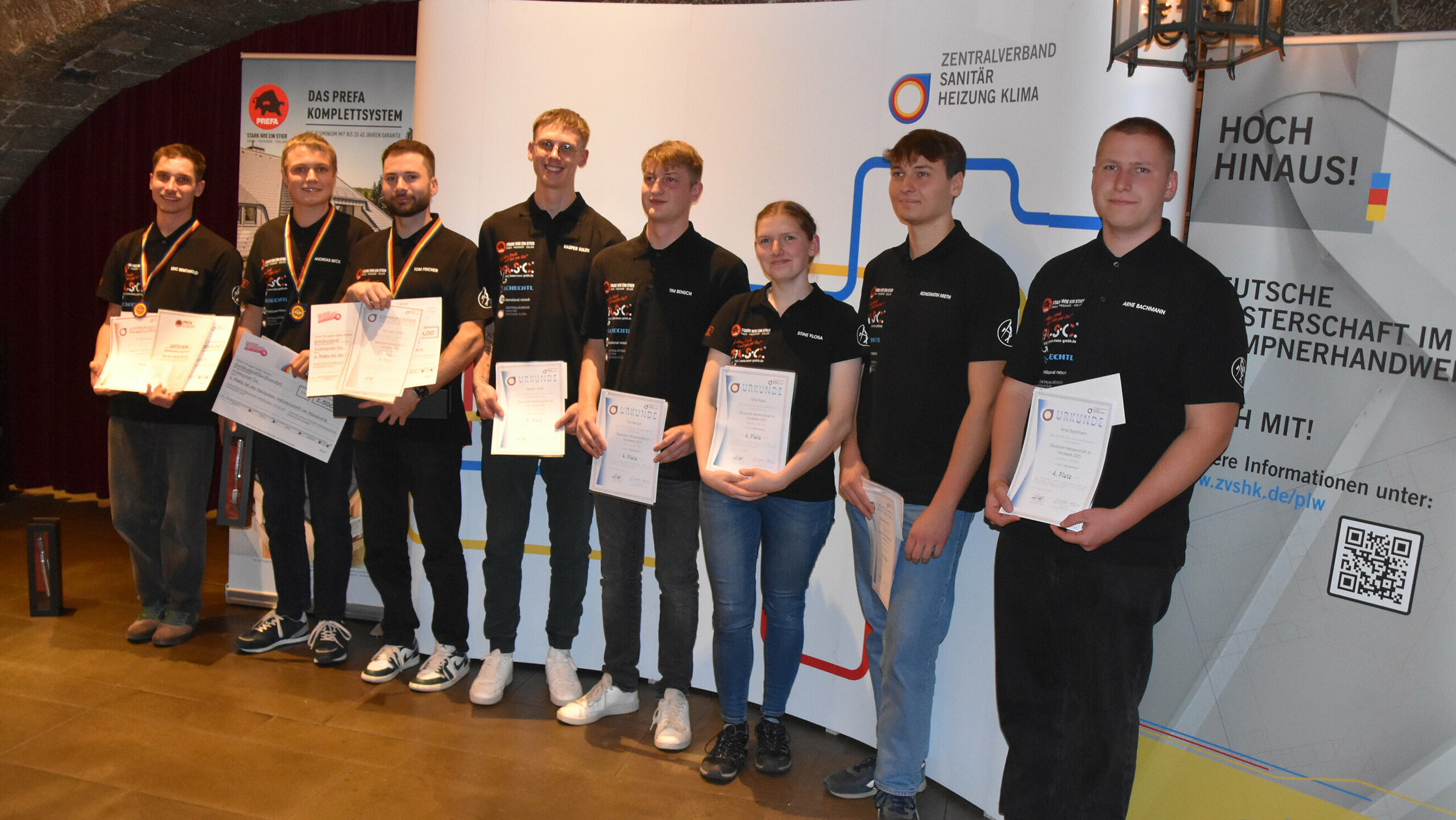 Die stolzen Gewinner und Teilnehmer der Deutschen Meisterschaft im Klempnerhandwerk präsentieren ihre Zertifikate und Medaillen auf der Siegerehrung.