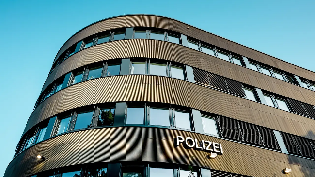 Dramatische Untersicht des geschwungenen Neubaus vom Polizeikommissariat 43 in Hamburg: Die markante PREFA Aluminiumfassade aus eloxierten Strangpressprofilen „Zacke“ in Mittelbronze zieht als architektonischer Eyecatcher alle Blicke auf sich. Die feine, rhythmische Struktur erzeugt dynamische Licht- und Schattenverläufe und betont die fließenden Rundungen des Baukörpers. PREFA Aluminium überzeugt durch hohe Witterungsbeständigkeit, Korrosionsschutz und Langlebigkeit – eine nachhaltige, wartungsarme Lösung für präzise, moderne Fassadenarchitektur.
