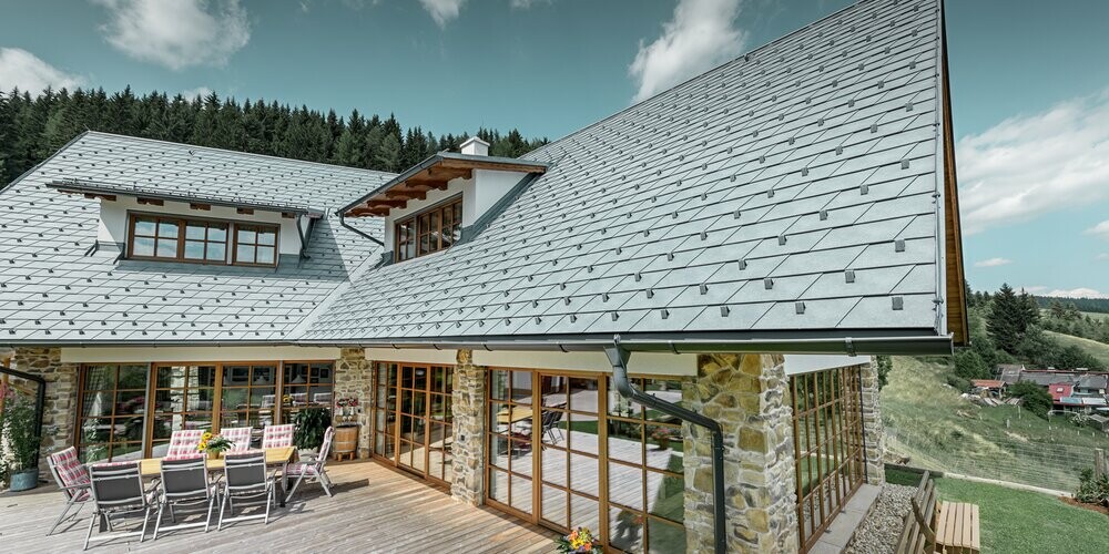 Einfamilienhaus eingedeckt mit PREFA Dachschindeln in der Farbe P.10 Steingrau