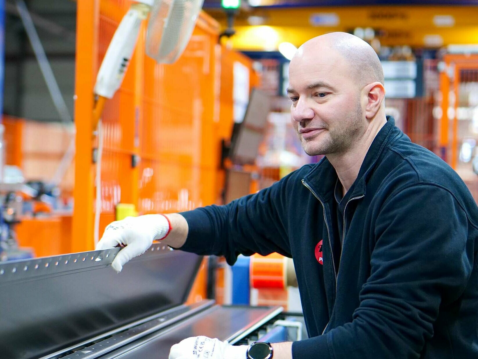 PREFA Mitarbeiter kontrolliert Siding an der Siding Maschine.