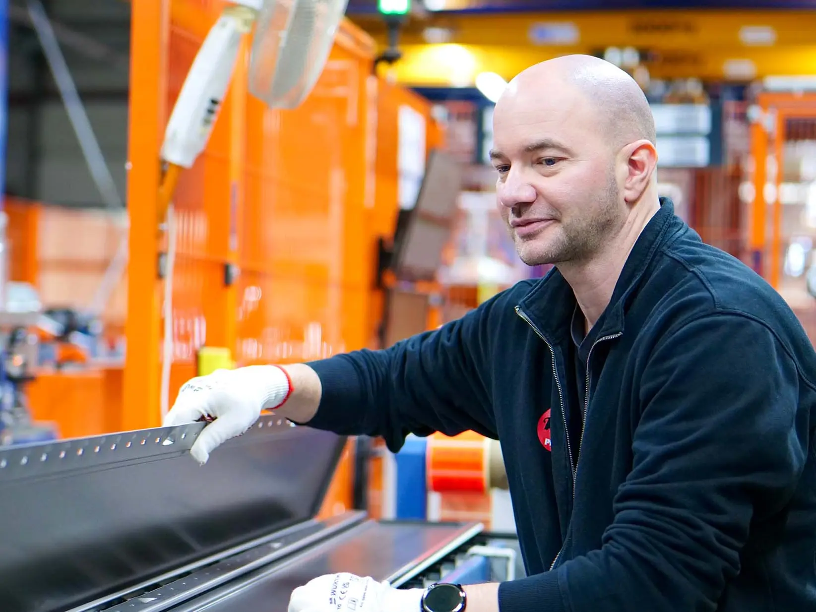 PREFA Mitarbeiter kontrolliert Siding an der Siding Maschine.