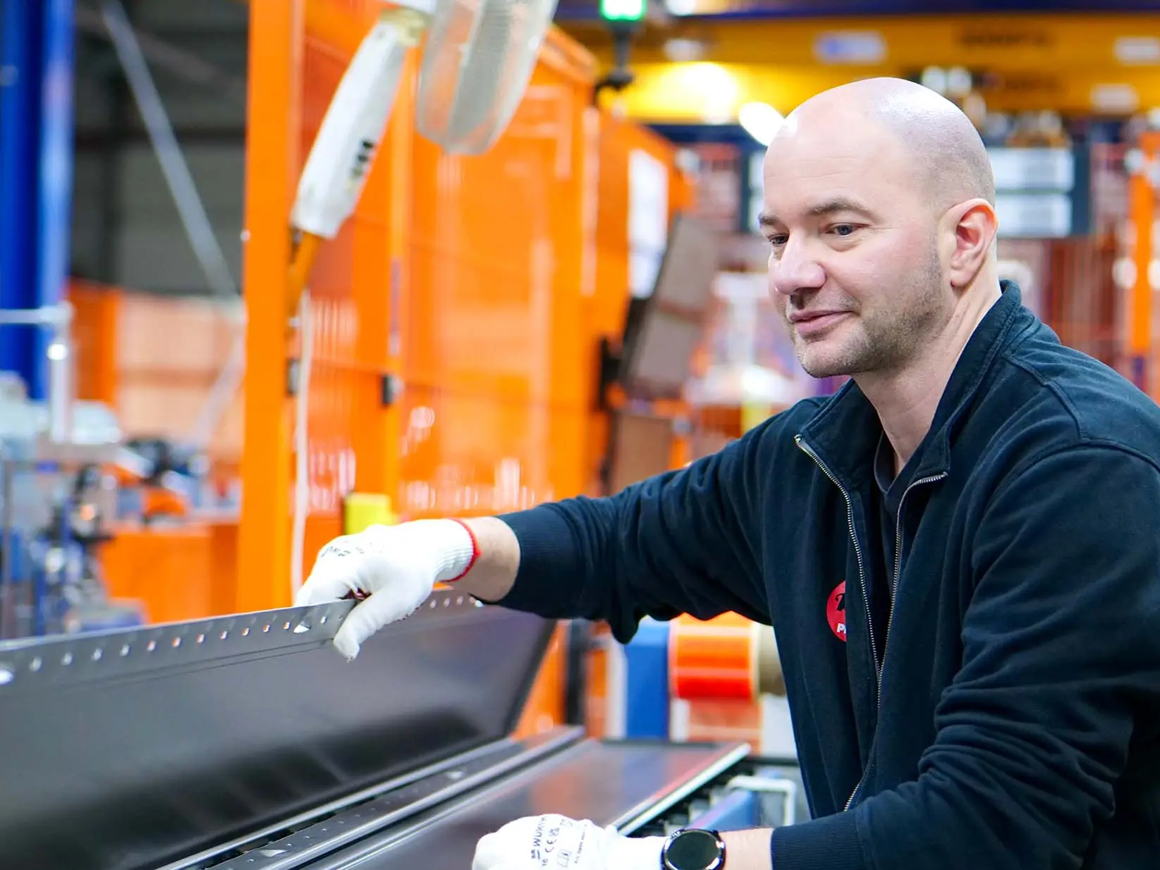 PREFA Mitarbeiter kontrolliert Siding an der Siding Maschine.