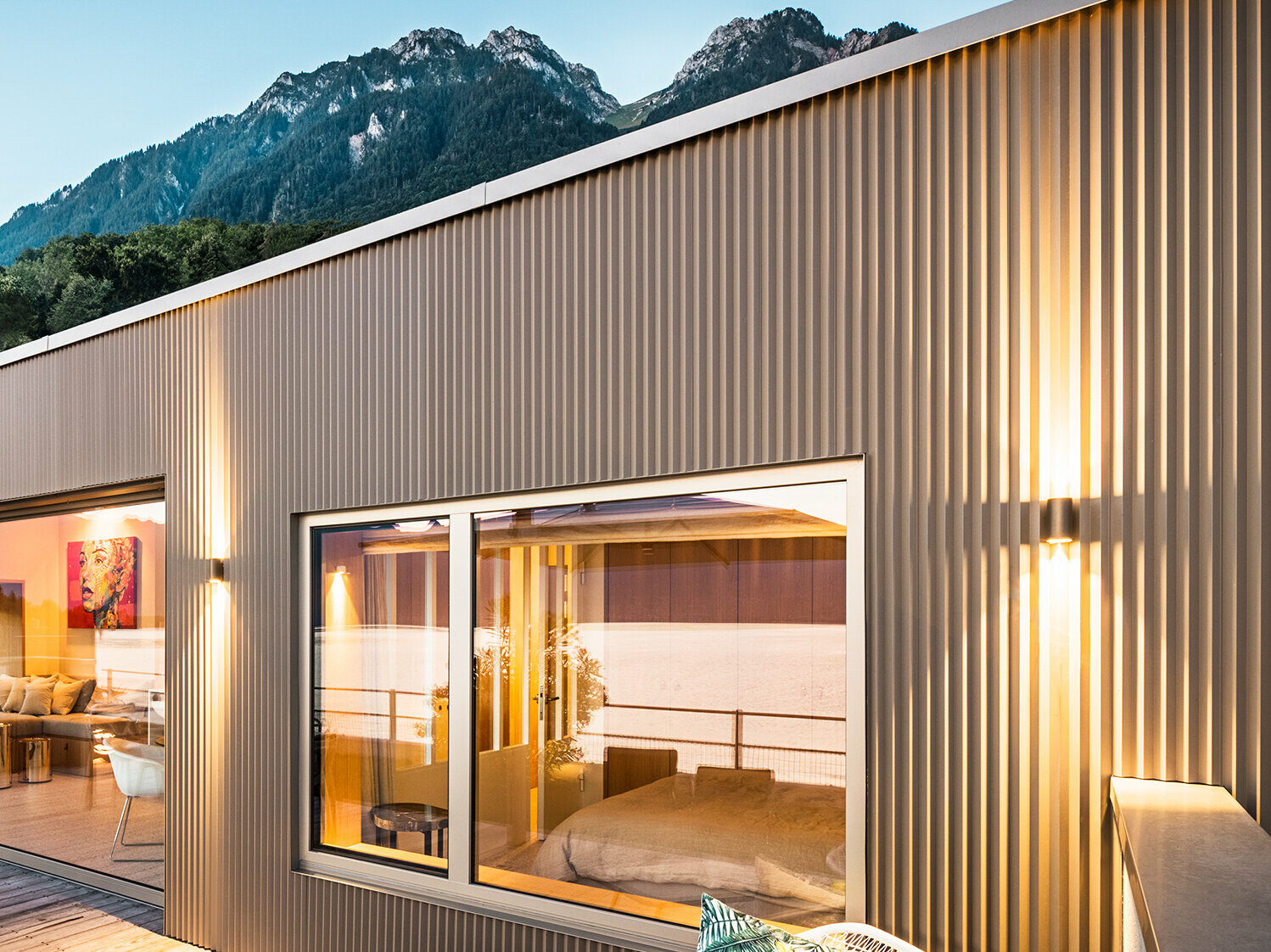 Blick auf die Terrasse und Teil des Gebäudeinneren am Abend.