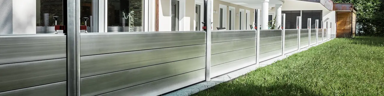 Die Aufnahme zeigt den mobilen Hochwasserschutz von PREFA, welcher das Einfamilienhaus im Hintergrund vor Hochwasser-Katastrophen schützt.