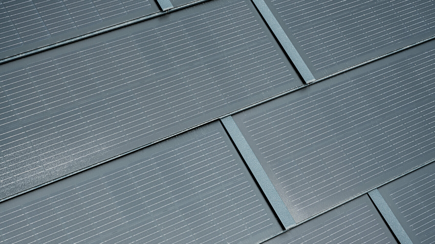 Detailaufnahme der verlegten PREFA Solardachplatte. Die Solardachplatte in der Farbe P.10 Anthrazit wurde mit der Dachplatte R.16 kombiniert. 