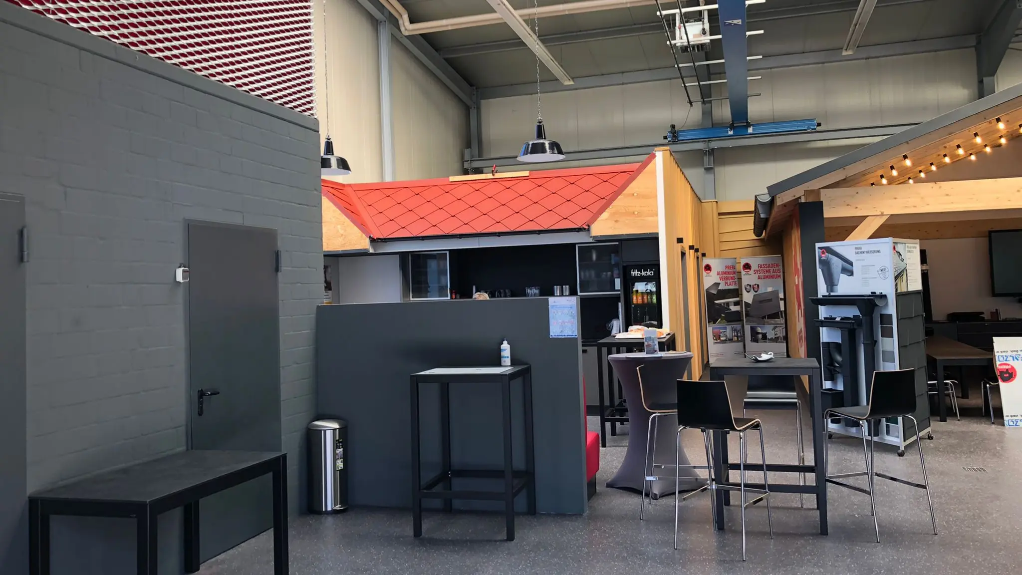 Die Innenräume des PREFA Schulungszentrums in Hamburg. Hier wurden bereits einige Übungsdächer eingedeckt. Auf einem der Dächer wurden Dachrauten der Größe 29x29 in der Farbe P.10 Oxydrot verlegt. 