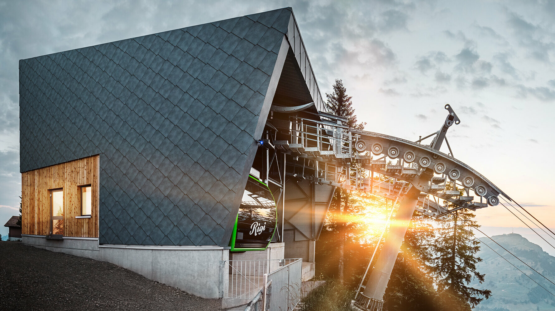 Luftseilbahn mit PREFA Dach und Fassade in der Schweiz bei Sonnenuntergang.