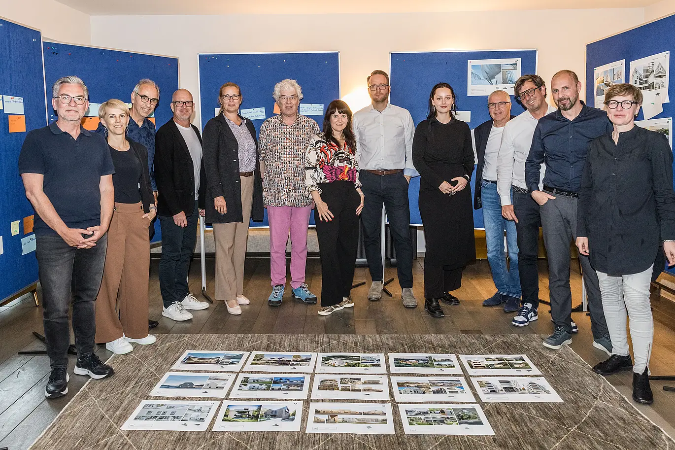 Gruppenfoto der PREFARENZEN 2026 Jury nach erfolgreichem Auswahlprozess in einer Winzerresidenz im burgenländischen Seewinkel: Die interdisziplinäre Expertengruppe bestehend aus Dirk Lorenz (Leinert Lorenz Architekten), Veronika Roll (Marketing, PREFA Österreich), Wolfgang Croce (Croce & Wir, Graz), Jürgen Jungmair (Marketingleiter International, PREFA), Judit Nemere (Geschäftsführung PREFA Ungarn), Matthias Finkentey (Moderation), Bettina Almeida (Kommunikationsmanagement, PREFA), Christian Wirth (Regionalleiter Ost, PREFA Österreich), Selina Wach (Head of Discourse, Architektur Aktuell), Thomas Schlett (B3 Architekten), Sven Disser (Leiter Development, Bauwerk), Falk Leinert (Leinert Lorenz Architekten) und Juliane Croce (Croce & Wir, Graz) steht vor den final ausgewählten Architekturprojekten für das PREFARENZEN Architekturbuch und den Kalender 2026. Die Projekte spiegeln Vielfalt, Nachhaltigkeit und innovativen Einsatz von PREFA Materialien wider.