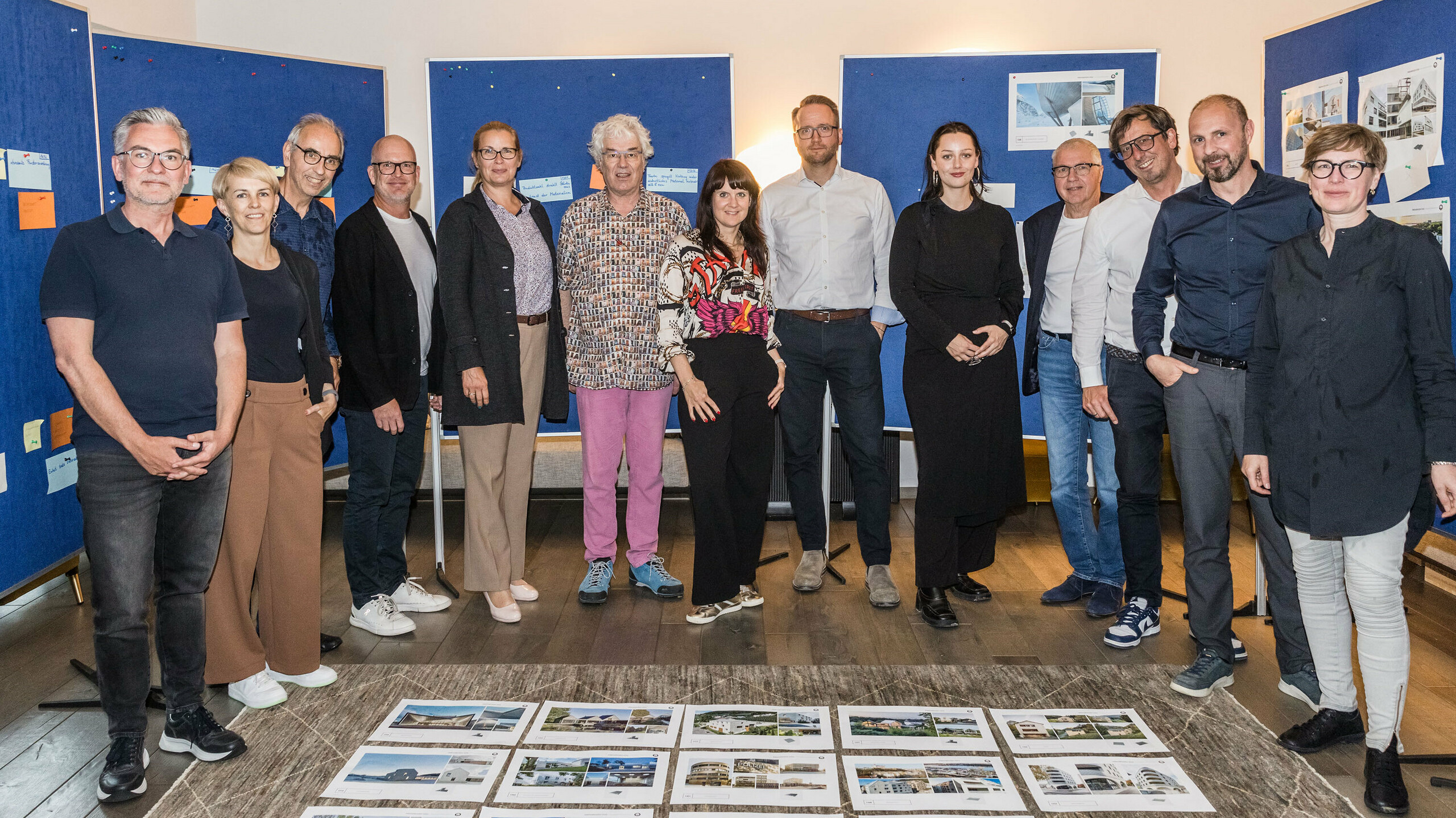 Gruppenfoto der PREFARENZEN 2026 Jury nach erfolgreichem Auswahlprozess in einer Winzerresidenz im burgenländischen Seewinkel: Die interdisziplinäre Expertengruppe bestehend aus Dirk Lorenz (Leinert Lorenz Architekten), Veronika Roll (Marketing, PREFA Österreich), Wolfgang Croce (Croce & Wir, Graz), Jürgen Jungmair (Marketingleiter International, PREFA), Judit Nemere (Geschäftsführung PREFA Ungarn), Matthias Finkentey (Moderation), Bettina Almeida (Kommunikationsmanagement, PREFA), Christian Wirth (Regionalleiter Ost, PREFA Österreich), Selina Wach (Head of Discourse, Architektur Aktuell), Thomas Schlett (B3 Architekten), Sven Disser (Leiter Development, Bauwerk), Falk Leinert (Leinert Lorenz Architekten) und Juliane Croce (Croce & Wir, Graz) steht vor den final ausgewählten Architekturprojekten für das PREFARENZEN Architekturbuch und den Kalender 2026. Die Projekte spiegeln Vielfalt, Nachhaltigkeit und innovativen Einsatz von PREFA Materialien wider.