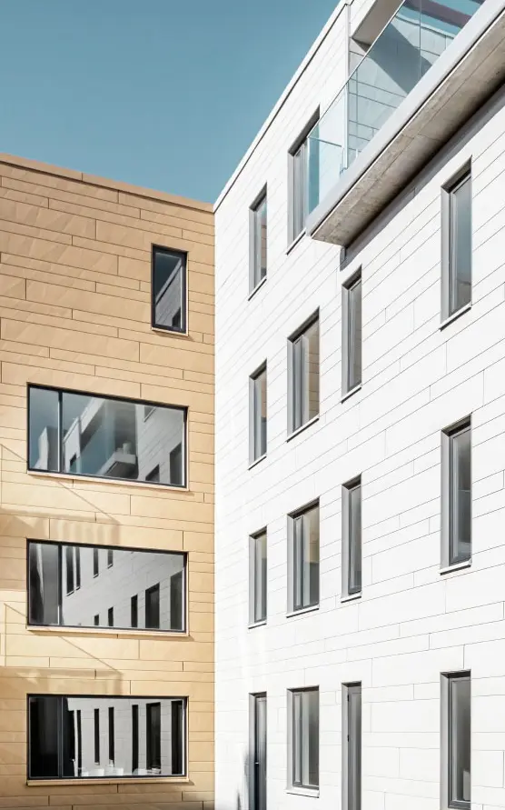 Moderne Gebäude mit PREFA Siding.X Fassade in zwei Farben, die das innovative Fassadenmaterial und die moderne Architektur betonen.