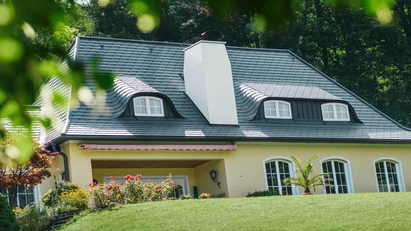 Hausdach und Hechtgaube saniert mit der PREFA Dachschindel mit großem Kamin
