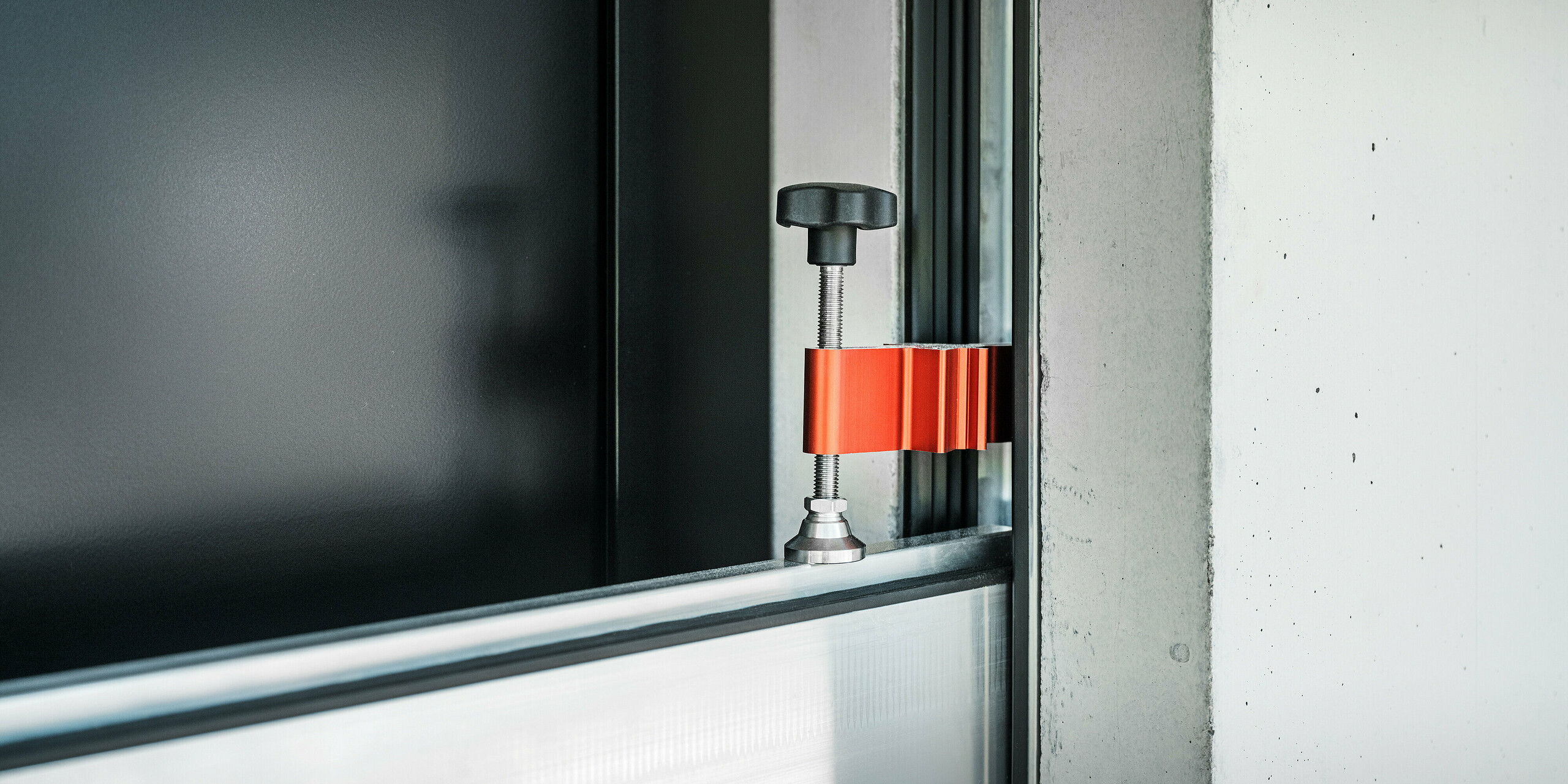Das PREFA Hochwasserschutzsystem im Einsatz an der Eingangstür eines Einfamilienhauses. Das Spannstück hält die stabilen Aluminiumprofile zusammen und verhindert zuverlässig das Eindringen von Wasser.