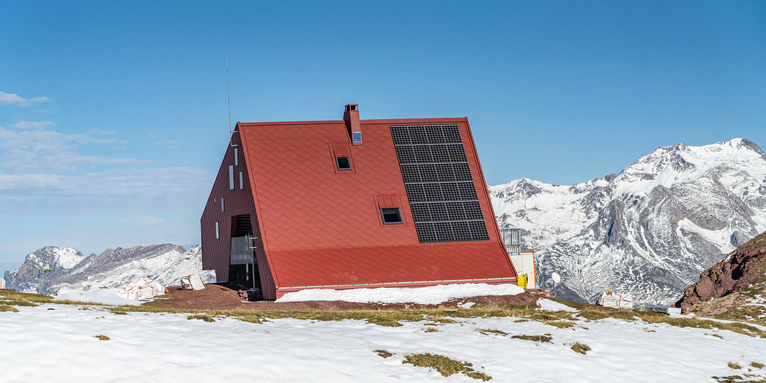 Rund um die Schutzhütte Arlet im Pyrenäen-Nationalpark ist eine traumhafte Berglandschaft zu sehen. Das Gebäude wurde mit PREFA Dach- und Wandrauten 44x44 in P.10 Oxydrot eingedeckt.
