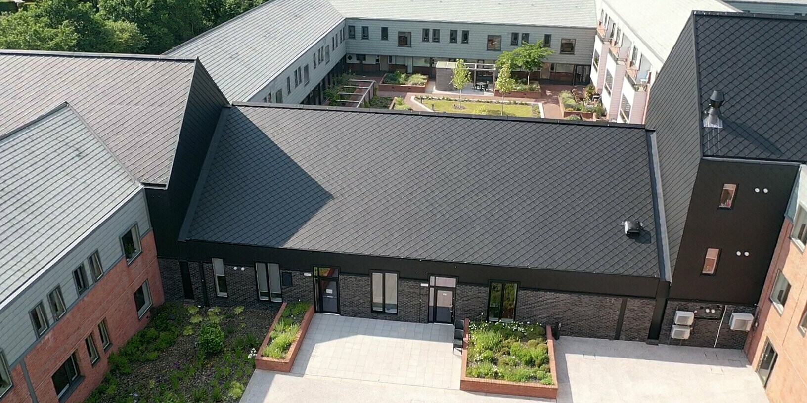 Vogelperspektive auf die Pflegeeinrichtung in Preston, die mit PREFA Dach- und Wandraute 29 × 29 in P.10 Schwarz verkleidet wurde.