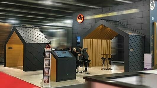 PREFA Messestand mit Messewänden in P.10 schwarzen Siding.X und Rauten und Falzonal in Savannenbeige.
