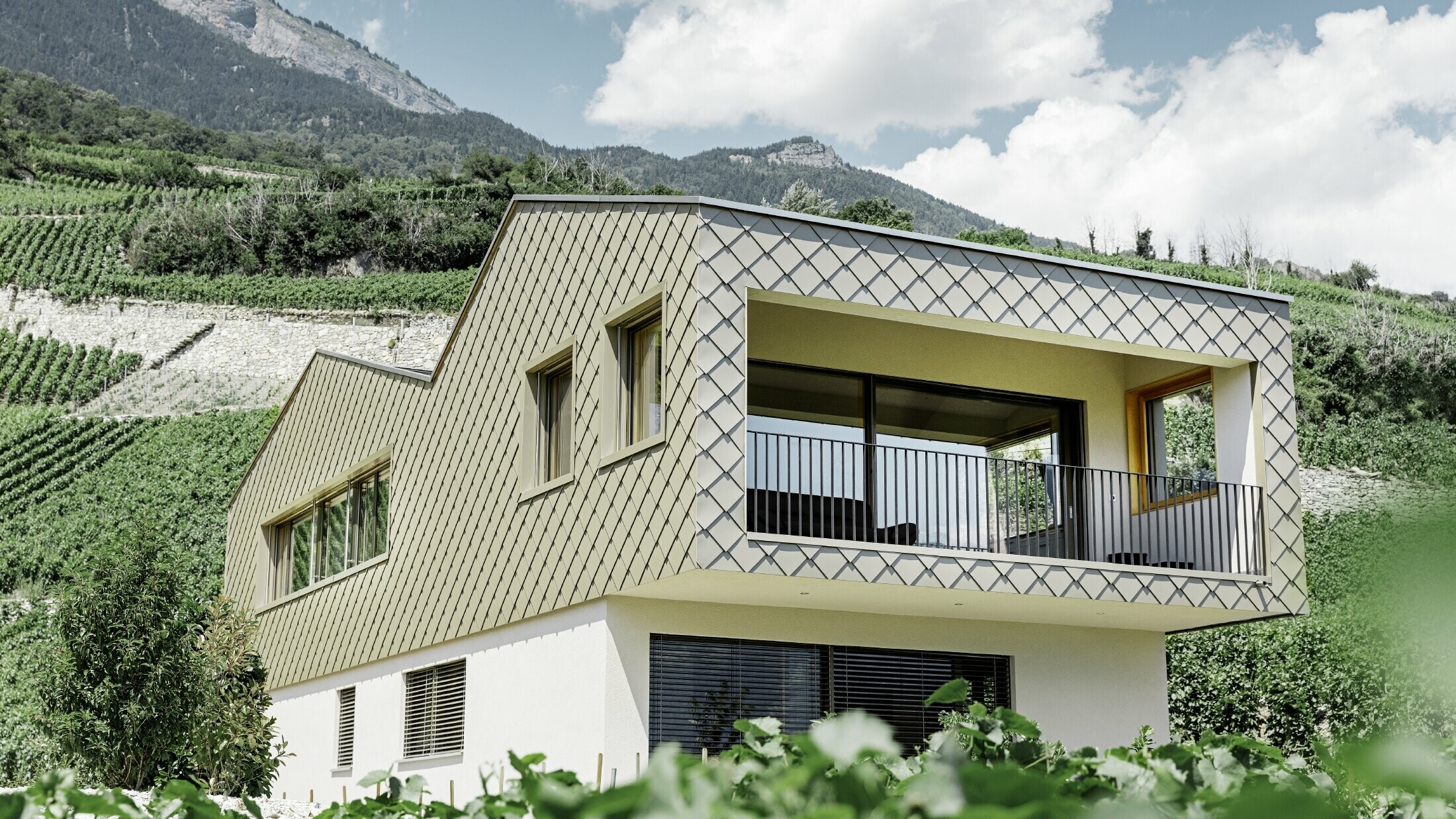 modernes Einfamilienhaus mitten in den Weinbergen des Rhônetals mit 4 unterschiedlichen Dachflächen und offener Galerie mit einer Rautenfassade in bronze