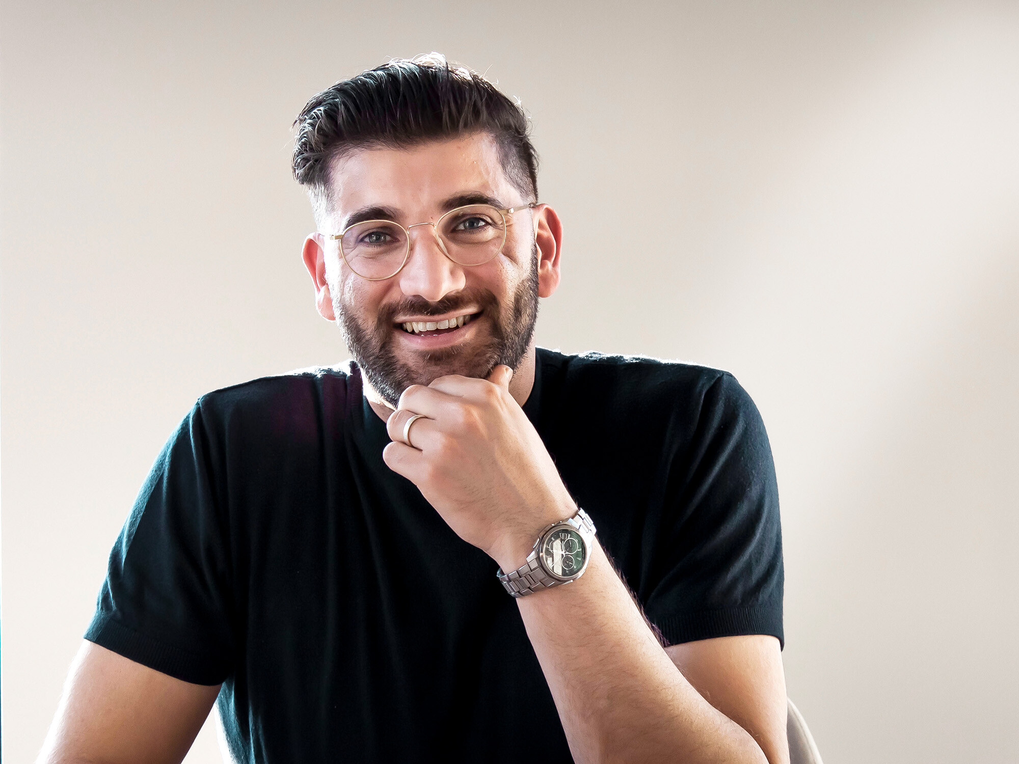 Lächelnder Architekt Hoeshmand Mahmoed von HMVD Architecten, sein Kinn auf der linken Hand abgestützt.