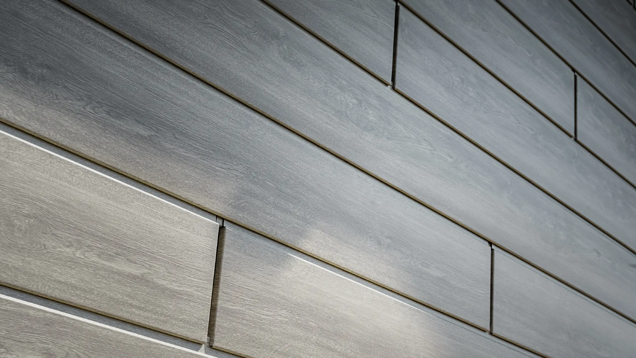 Nahaufnahme der PREFA Sidings Aluminium Fassade, die Alu-Paneele wurden horizontal verlegt und in Holzoptik - Eiche beige grau