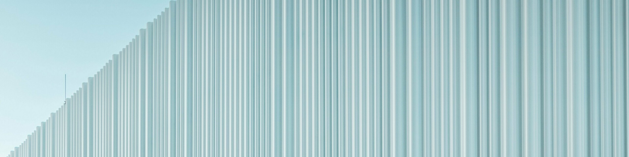 Eine spektakuläre Fassadengestaltung mit PREFA Strangpressprofil Welle aus hochwertigem Aluminium ziert das Firmengebäude von LKW Walter in Wien. Die sanft geschwungene, vertikal verlaufende Profilstruktur erzeugt ein elegantes Wellenbild, das faszinierende Lichtspiele erzeugt. Während das moderne Gebäude mit einer klaren Formsprache überzeugt, schafft der geschwungene Fassadenausschnitt einen markanten architektonischen Kontrast. Die langlebigen und korrosionsbeständigen Aluminiumprofile mit verdeckter Befestigung sorgen für eine hochwertige und wartungsfreie Außenhaut.