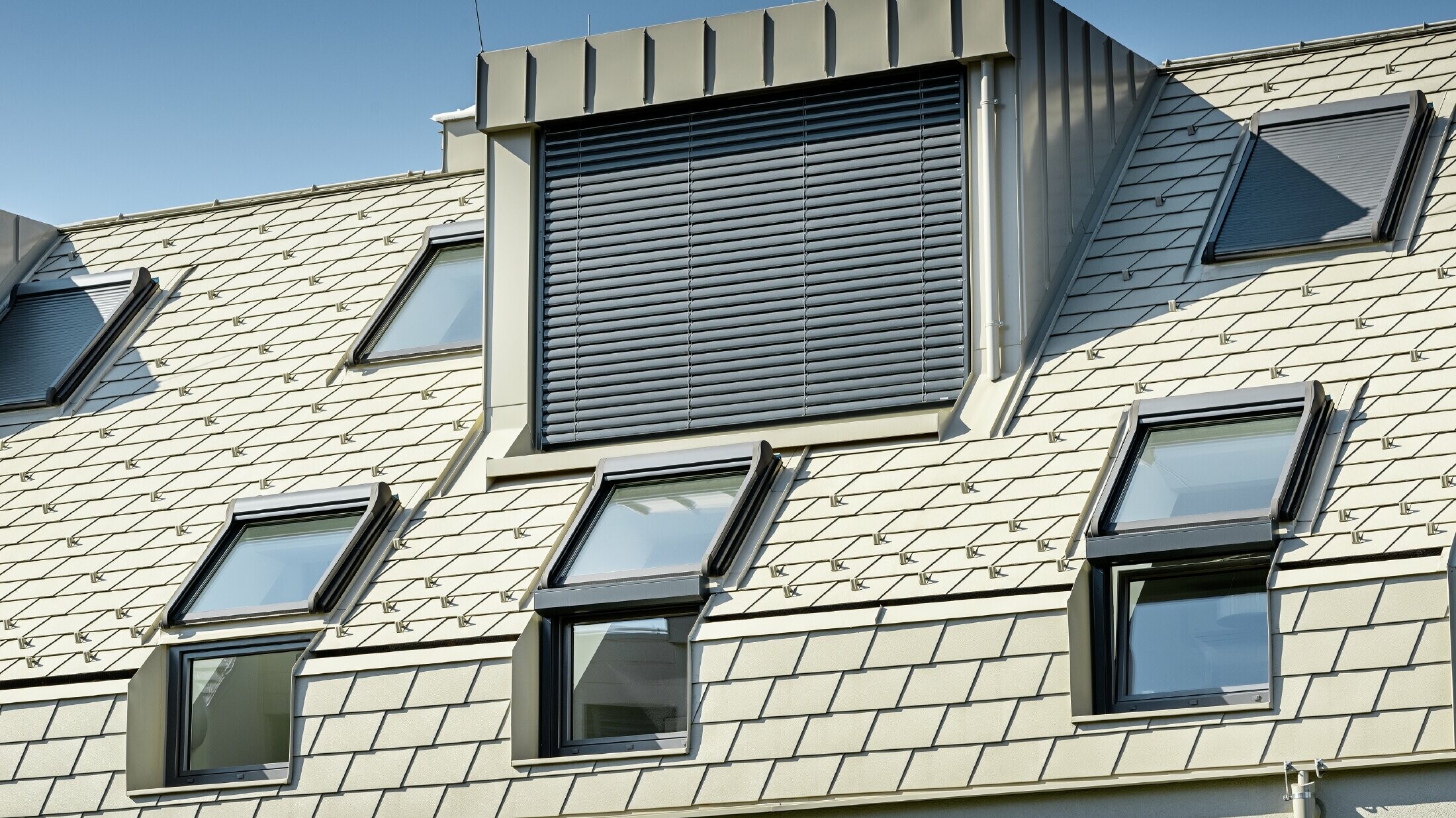 neue Wohnhausanlage mit großer Aluminium Dachfläche und vielen Dachflächenfenstern 