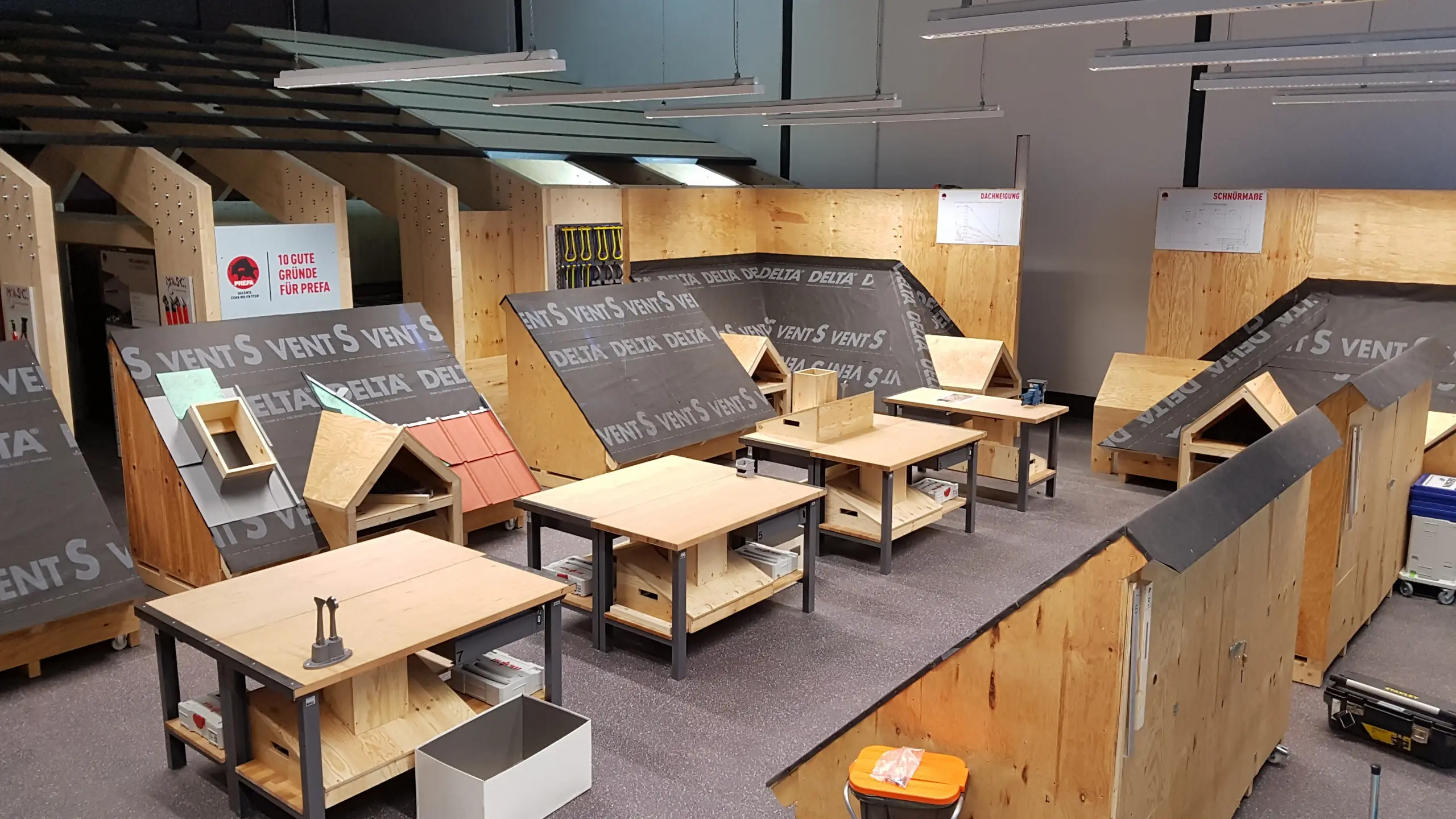 Die Innenräume der PREFA-Academy in Neu-Ulm. Hier stehen Dachmodelle. Auf einem der Modelle wurden bereits Dachplatten in P.10 oxydrot verlegt.