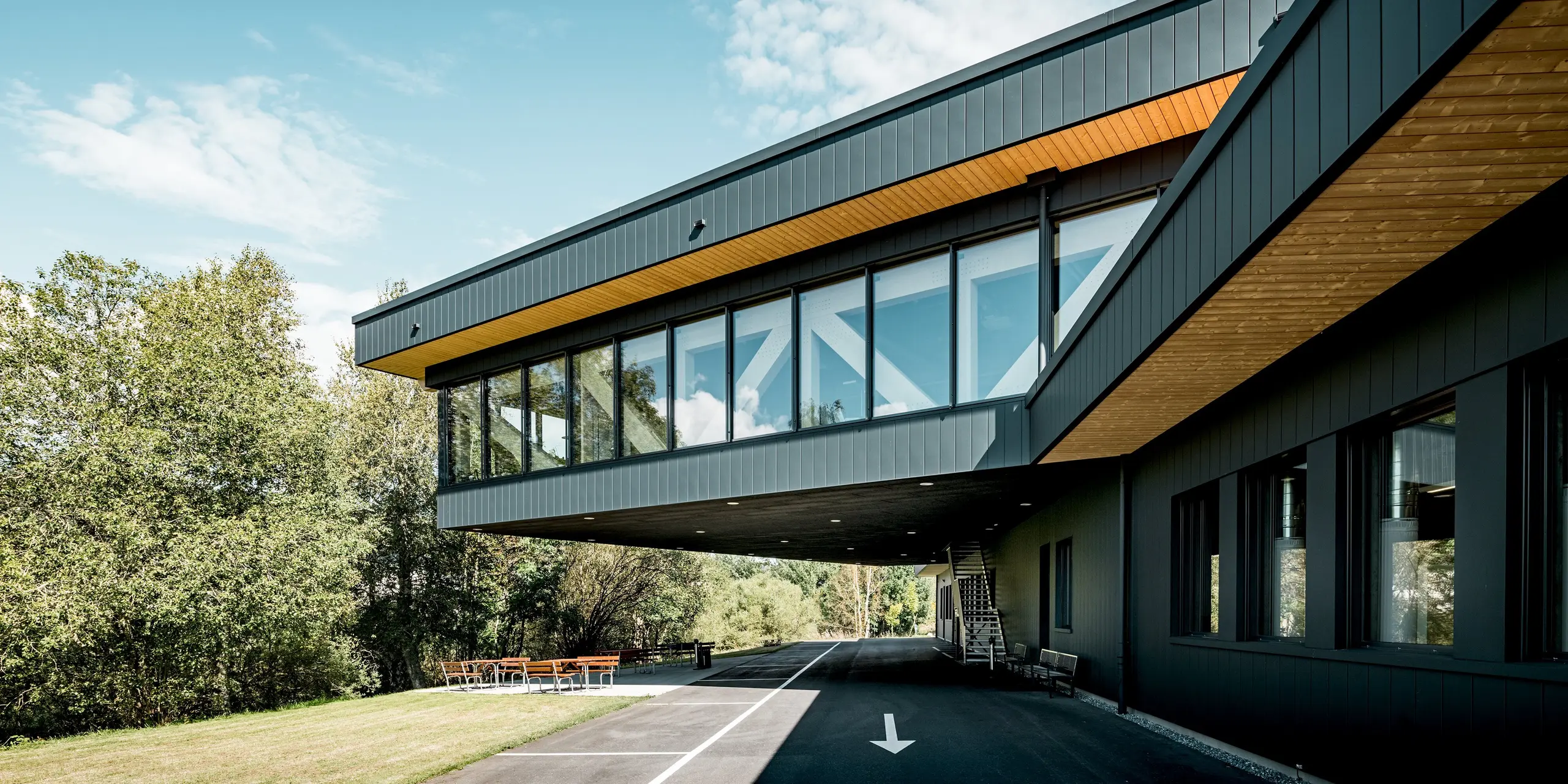 Das Firmengebäude von KIF Parechoc in Le Brassus beeindruckt mit seiner auskragenden Architektur, großflächigen Verglasungen und einer markanten Fassade aus PREFA Sidings in P.10 Anthrazit. Die dunklen Aluminiumflächen setzen einen spannenden Kontrast zu den warmen Holzuntersichten und der natürlichen Umgebung. PREFA Aluminium überzeugt durch Langlebigkeit, Korrosionsbeständigkeit und einen besonders geringen Wartungsaufwand.