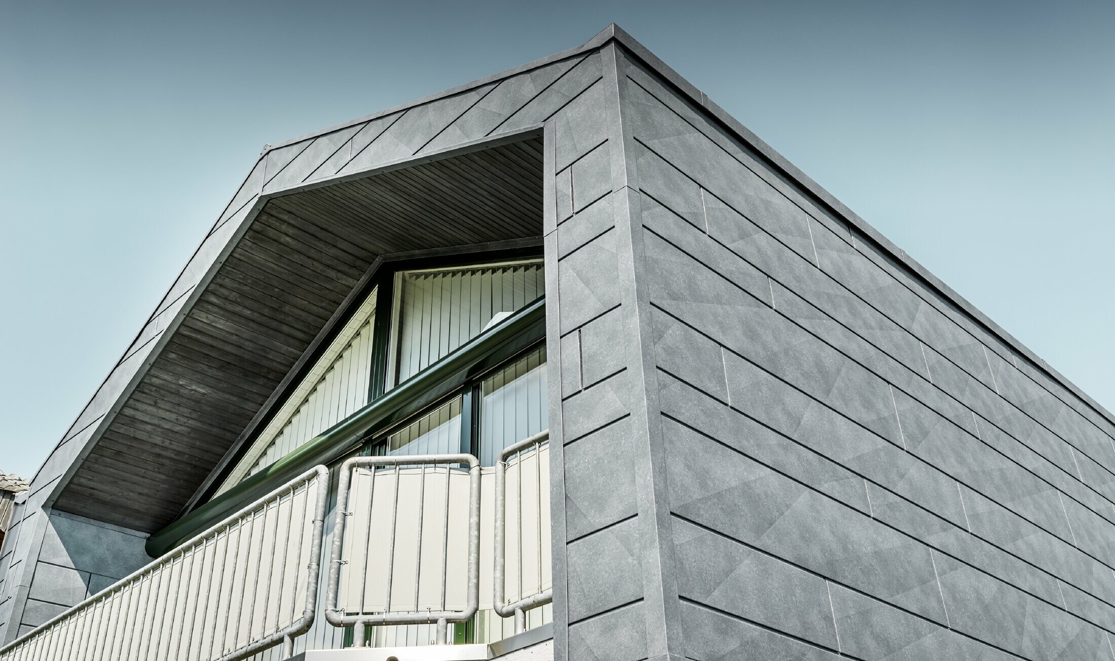 Fassadensanierung mit dem PREFA Siding.X in Steinoptik mit Balkon.