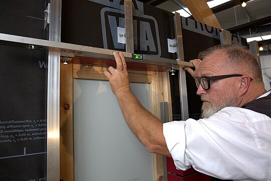 Kontrolle der Ausrichtung der Verbundplatte am Fenstersturz mittels Wasserwaage.