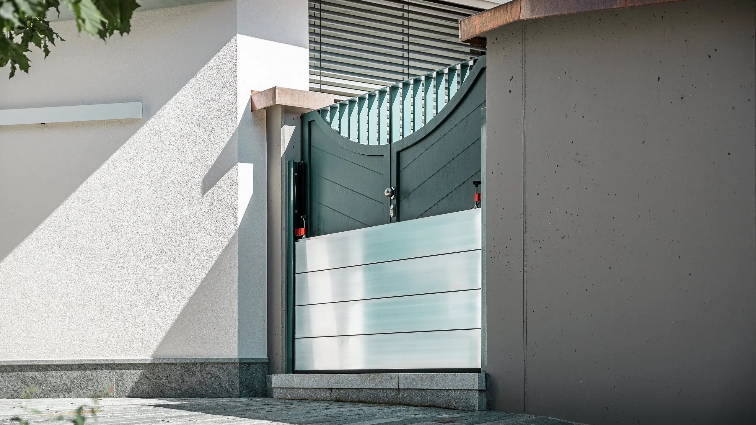 Nahaufnahme eines montierten PREFA Hochwasserschutzsystems am Gartentor eines Einfamilienhauses in Schwaz, Tirol. Die eingesetzten Dammbalken aus Aluminium sind in seitlich angebrachte Befestigungsprofile eingeschoben und schützen den Eingangsbereich zuverlässig vor eindringendem Wasser. Das System überzeugt durch seine schlichte Optik, die schnelle Einsatzbereitschaft und die korrosionsbeständigen Materialien - ideal für den privaten Objektschutz. Die Wandprofile sind in der gleichen Farbe wie die Tür gehalten, so dass ein harmonischer Gesamteindruck entsteht.