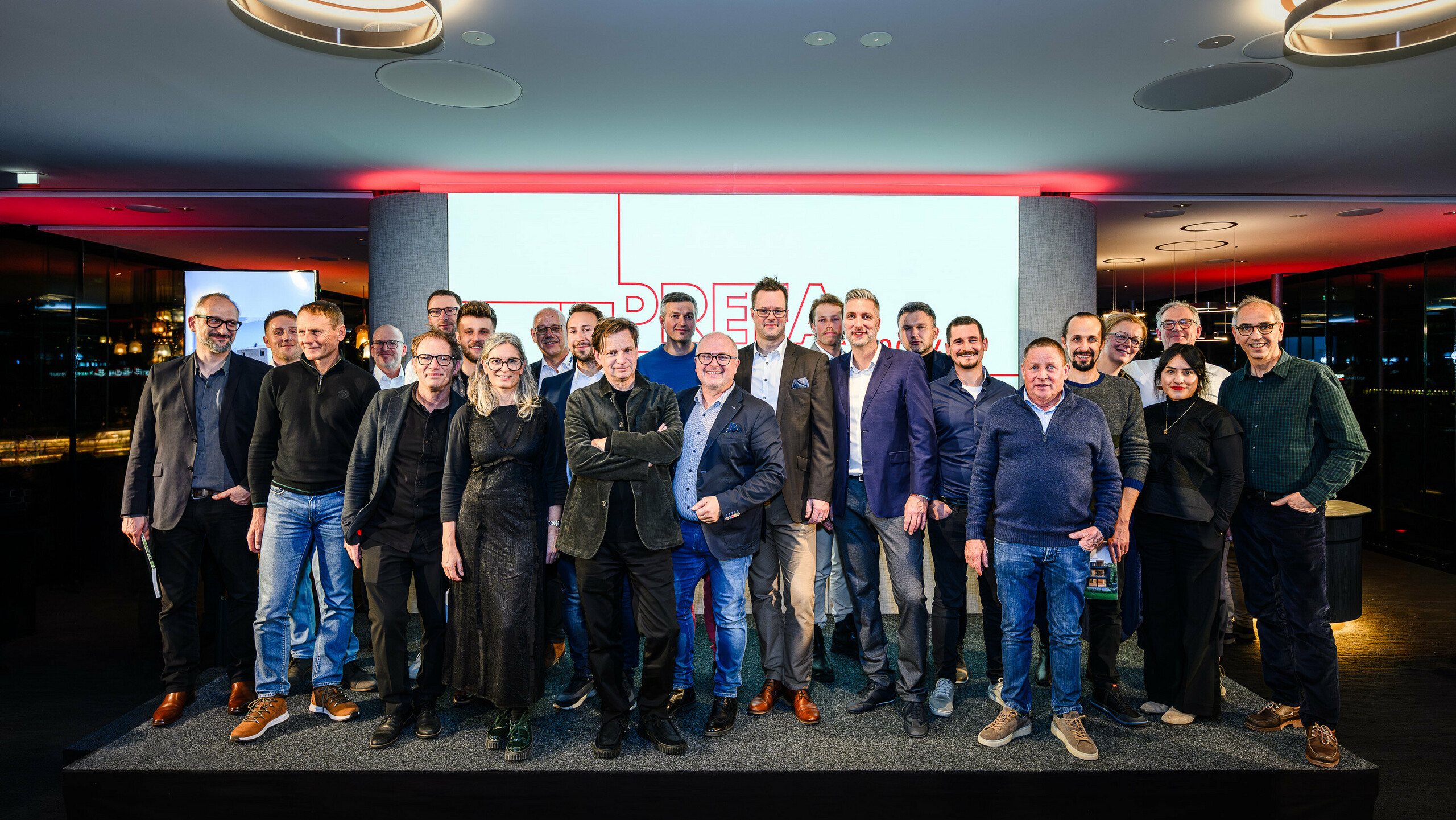 Gruppenfoto der Architekt:innen, Planer:innen und Verarbeiter:innen auf der Bühne der PREFARENZEN Präsentation 2026 im k47.wien – ein starkes Symbol für Gemeinschaft, Kreativität und zukunftsweisende Architektur. Vor dem leuchtenden PREFARENZEN-Logo stehen die Gestalter:innen hinter den beeindruckenden Projekten mit PREFA Aluminium. Die Szene spiegelt Stolz, Innovation und Zusammenarbeit wider. PREFA Produkte bieten langlebige, witterungsbeständige Lösungen mit ästhetischem Anspruch – ideal für moderne Architekturkonzepte. Ein inspirierender Abend voller Austausch, Visionen und starken Partnerschaften.