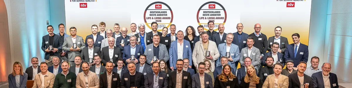 Gruppenfoto der Preisträgerinnen und Preisträger des Life & Living Award 2026 auf einer Bühne, alle mit ihren Auszeichnungen in den Händen.