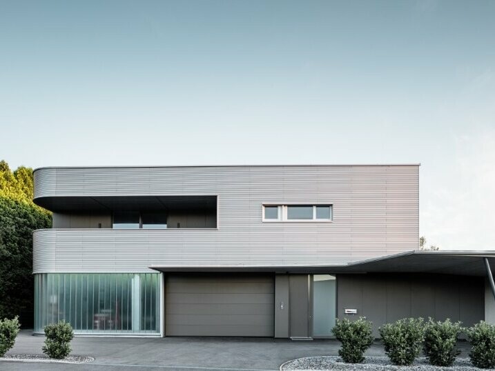 Vorderansicht des Hauses in Leonding in Linz bei Tag, verkleidet mit der PREFA Profilwelle natureloxiert