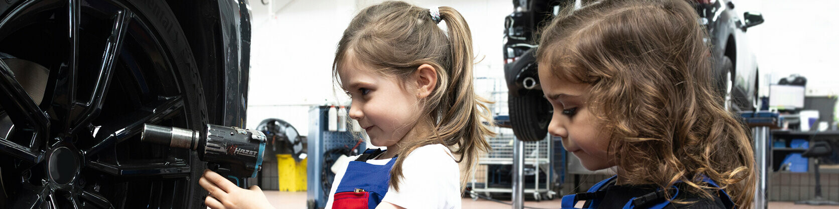 Zwei Mädchen im Kindergartenalter versuchen sich in einem handwerklichen Beruf. PREFA sponsert auch im Jahr 2025 den Kita-Wettbewerb "kleine Hände, große Zukunft".