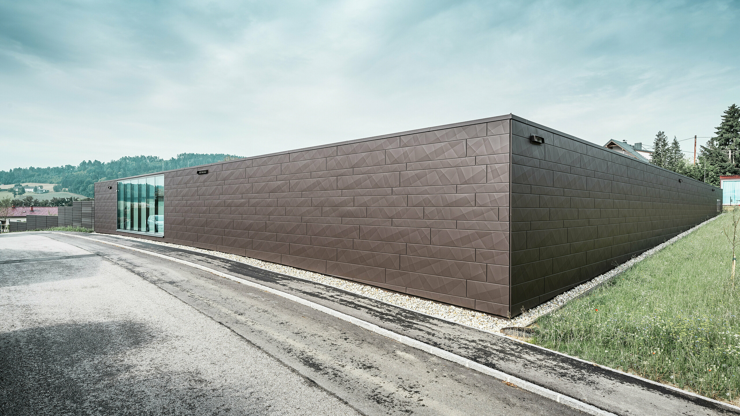 Lebensmittelgeschäft mit Siding.X Fassade. Die nussbraunen Paneele mit ihren individuellen Kantungen lassen das Gebäude besonders modern aussehen.