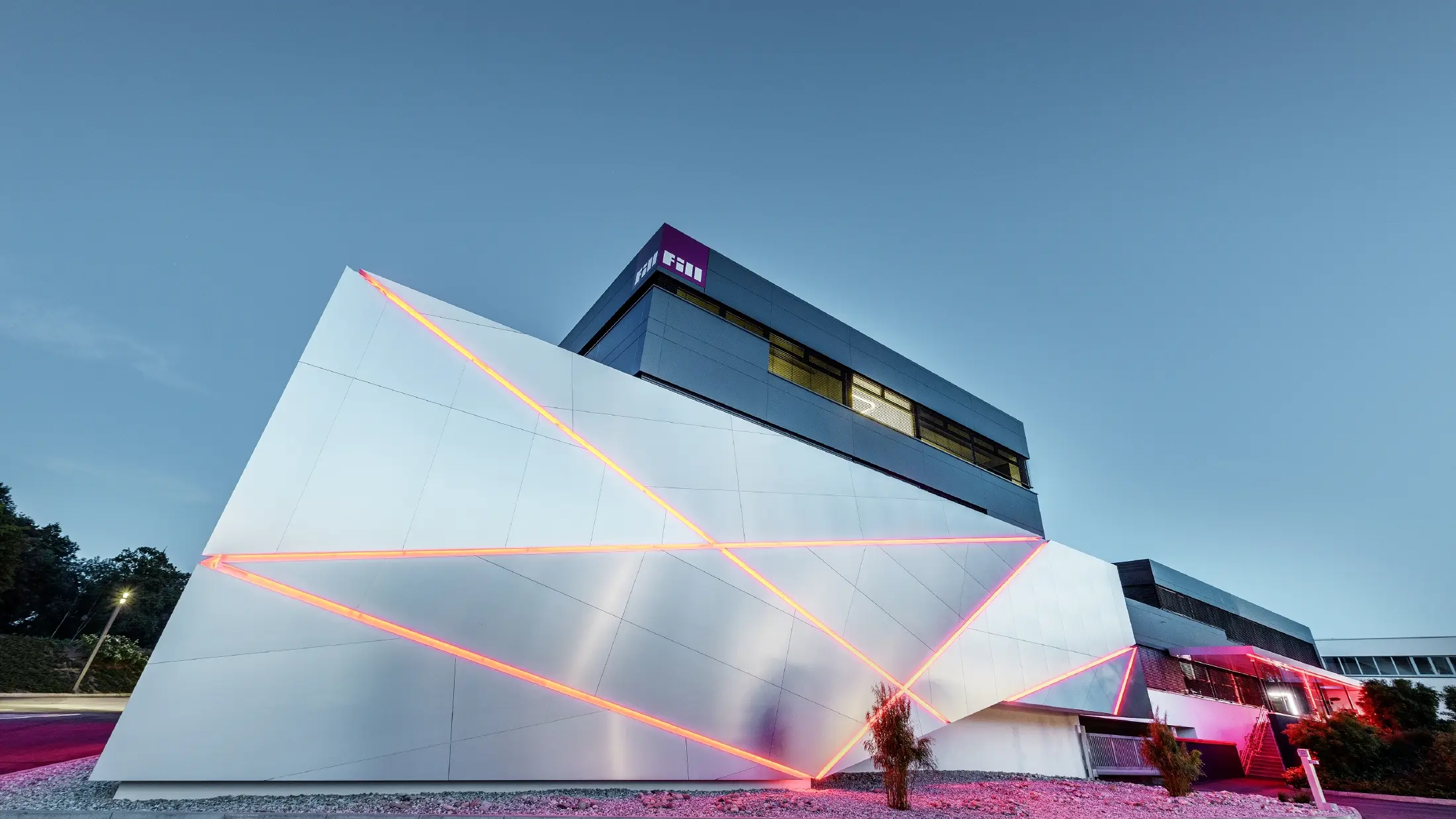 Fill Firmengebäude mit futurischer Aluminium Verbundplattenfassade in aluminium gebürstet und hinterleuchtetem Fugenbild