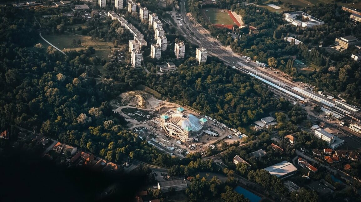 Weitwinkelblick auf den Gebäudekomplex in Ungarn. Im Hintergrund sind Wohnhäuser zu sehen