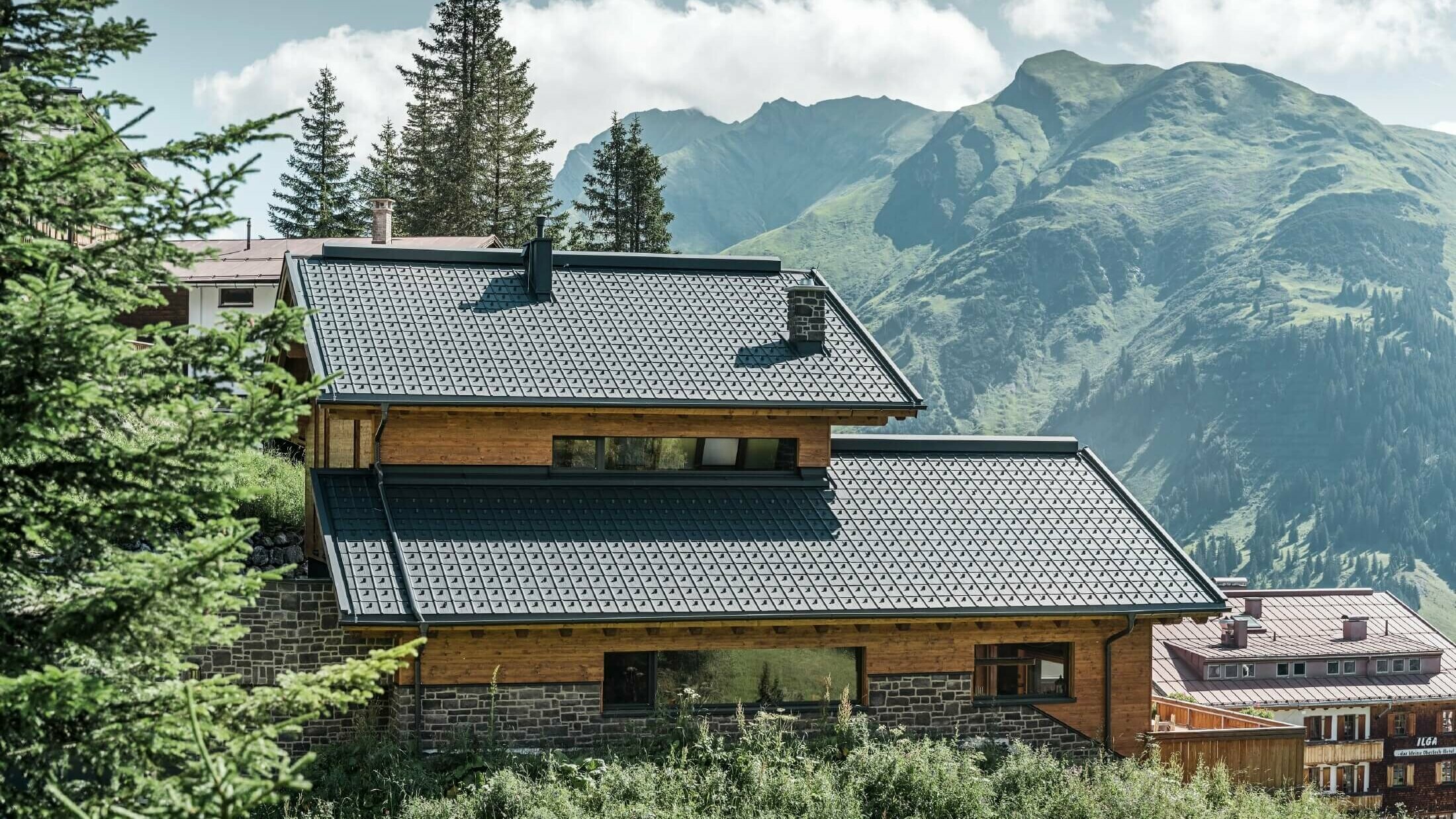 Haus in alpiner Lage mit anthrazitfarbenen PREFA Dachplatten als Dacheindeckung