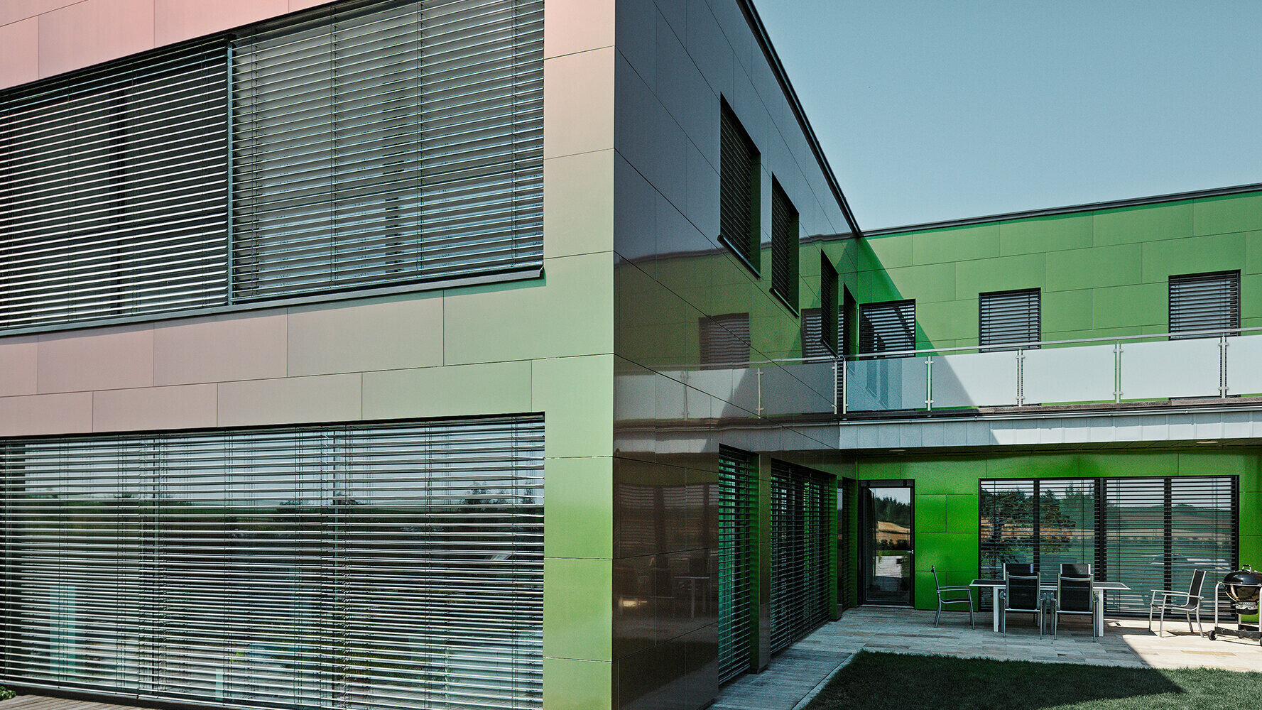 Die Verbundplatten-Fassade dieses Wohnhauses erscheint je nach Licht und Perspektive in Braun, Grün oder Dunkelviolett.