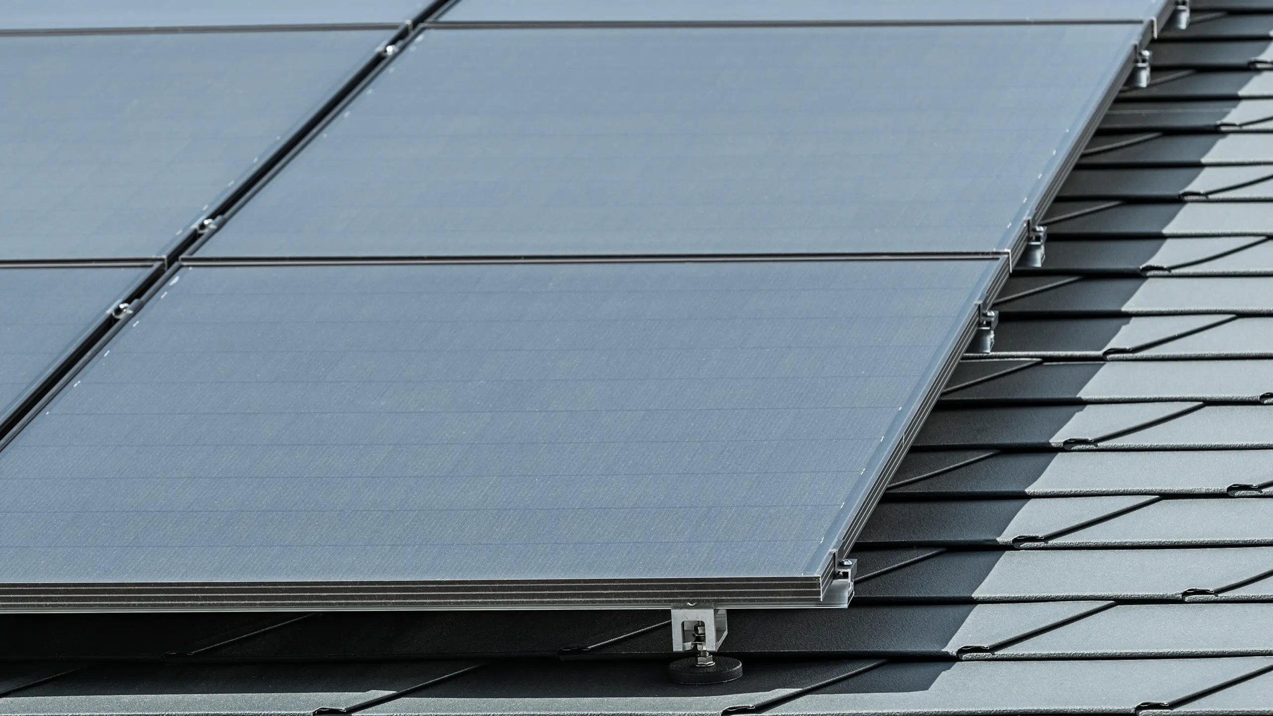 Detailaufnahme einer Photovoltaikanlage auf PREFA Dachschindeln DS.19 in P.10 Anthrazit montiert mit PREFA Solarhalter Vario