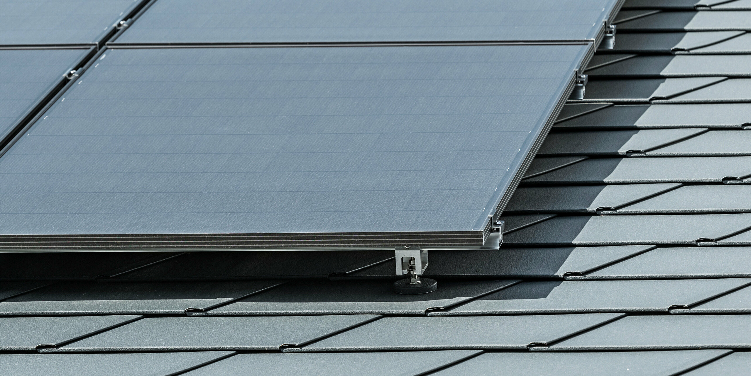 Detailaufnahme einer Photovoltaikanlage auf PREFA Dachschindeln DS.19 in P.10 Anthrazit montiert mit PREFA Solarhalter Vario