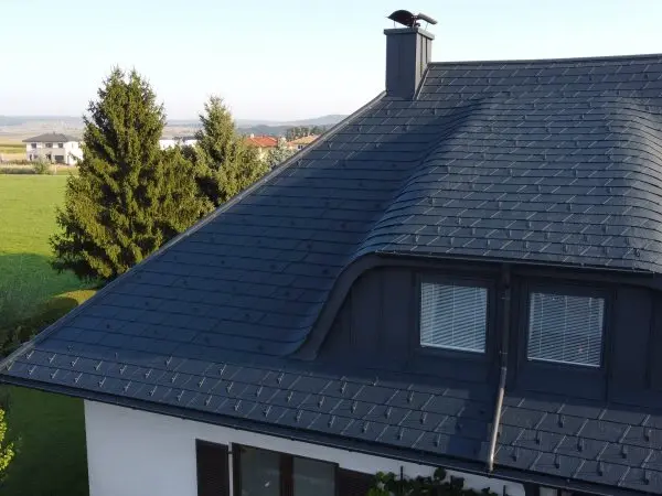 Nahaufnahme der Hechtgaube bei strahlendem Sonnenschein. Für die Sanierung entschied sich der Bauherr für die Dachschindel DS.19 in der Farbe P.10 Anthrazit