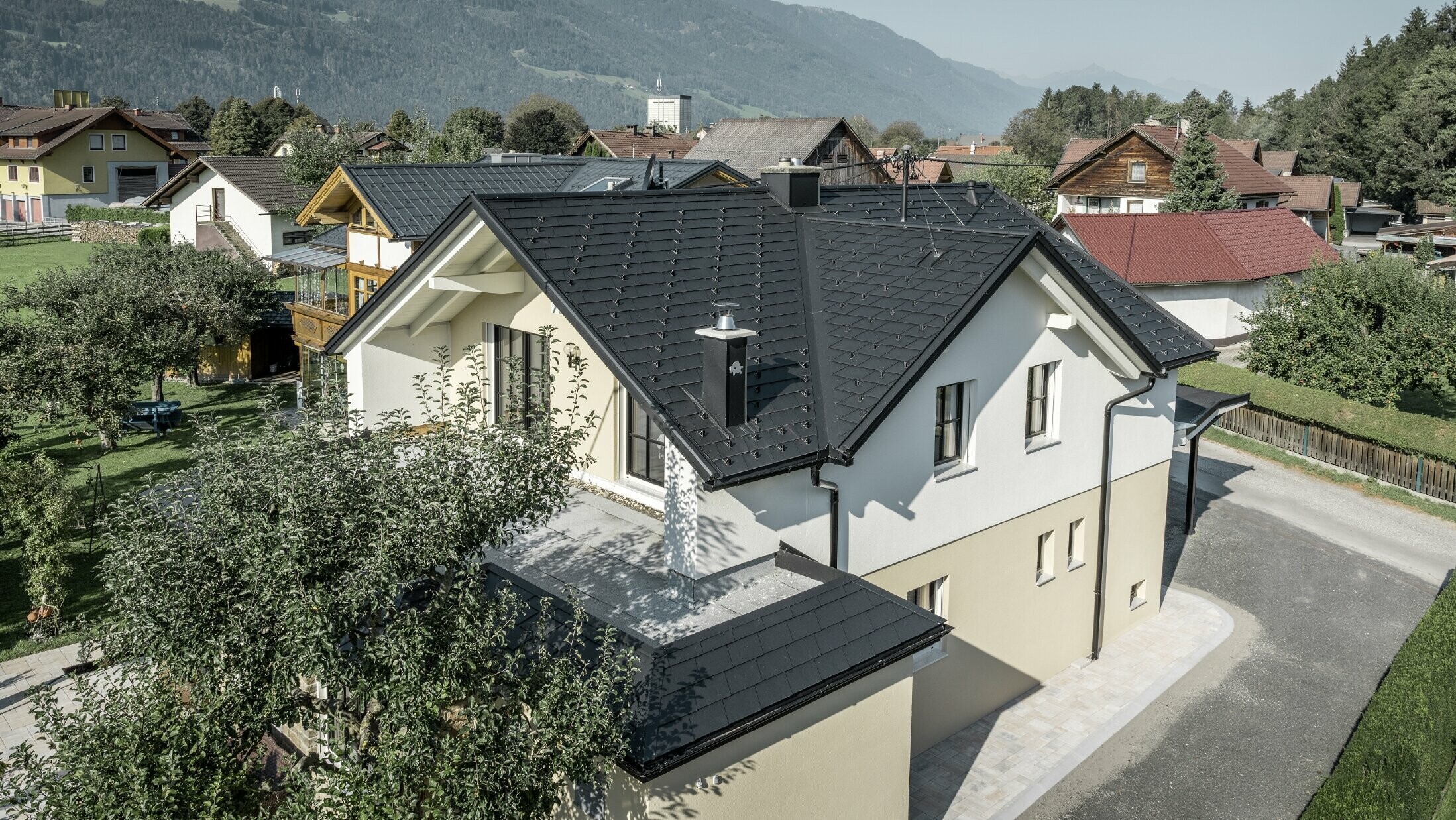 Traditionelles Einfamilienhaus mit Satteldach und großer Gaube, frisch saniert. Das Dach ist mit schwarzen Dachschindeln von PREFA eingedeckt.