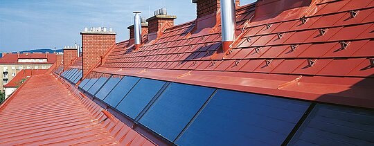 Detailaufnahme der PREFA Dachschindel in Ziegelrot inklusive Schneestoppern beim Hugo Breitner Hof.