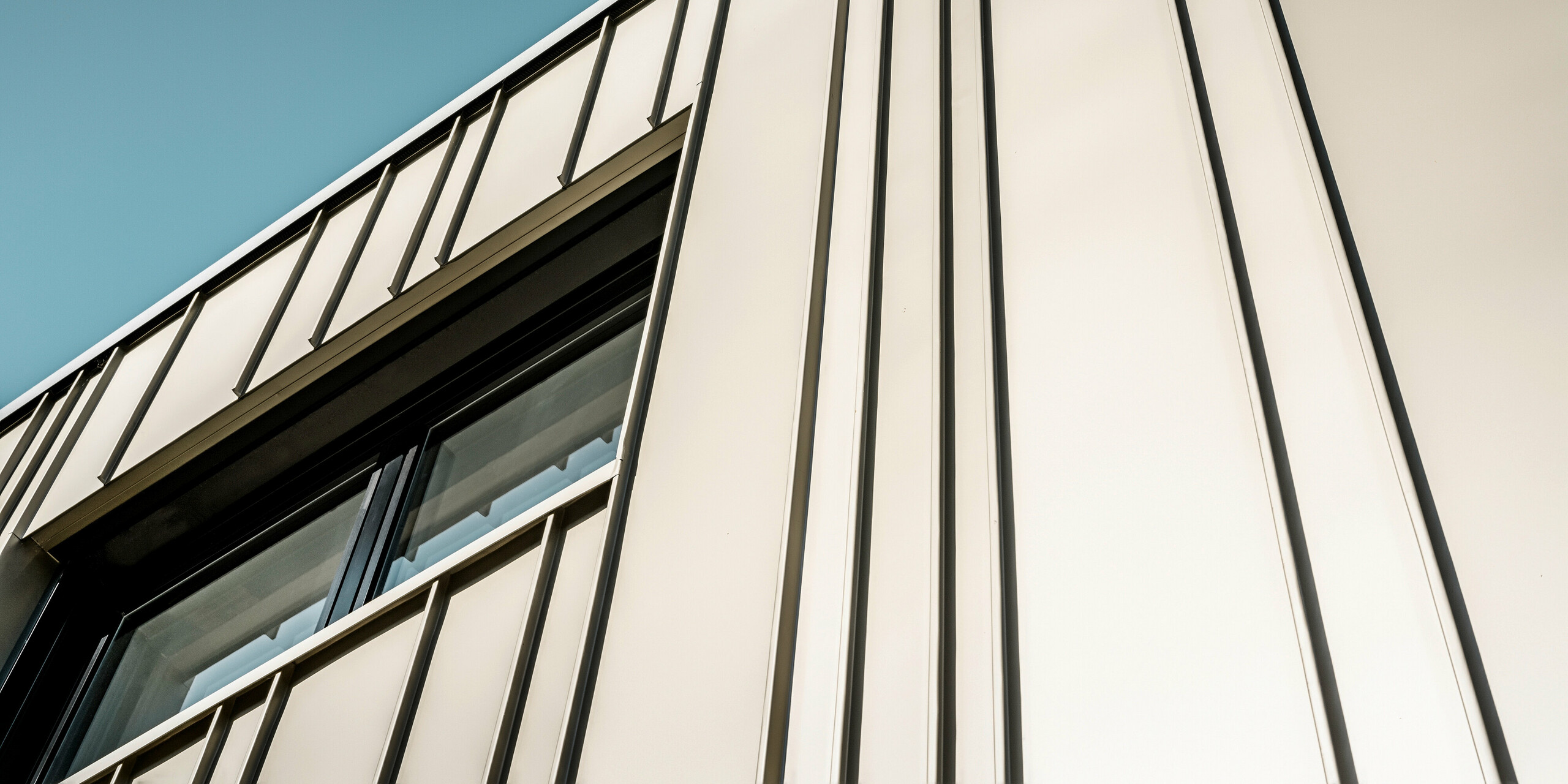 Ein Neubau in Bad Münstereifel wurde eingedeckt mit der PREFA Dachplatte R.16 in anthrazit. Auf dem Dach befindet sich eine Photovoltaik-Anlage. Die Winkelfalzfassade besteht aus Falzonal in lichtbronze.