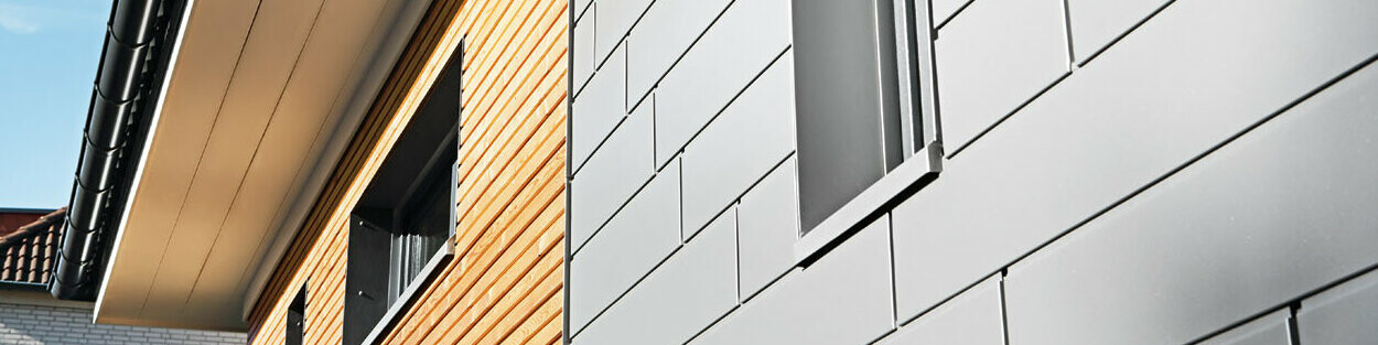 Kombination von Aluminiumg - PREFA Siding in Graualuminium - mit einer Holzfassade. Horizontale Verlegung, versetzte Fugen.