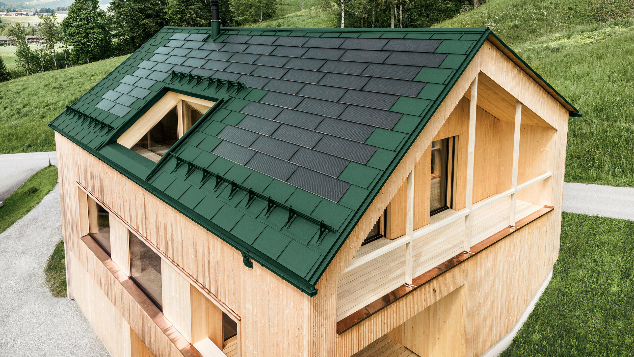 Einfamilienhaus im österreichischen Ort Egg mit der PREFA Solardachplatte und der Dachplatte R.16 in Moosgrün, kombiniert mit einer Holzfassade