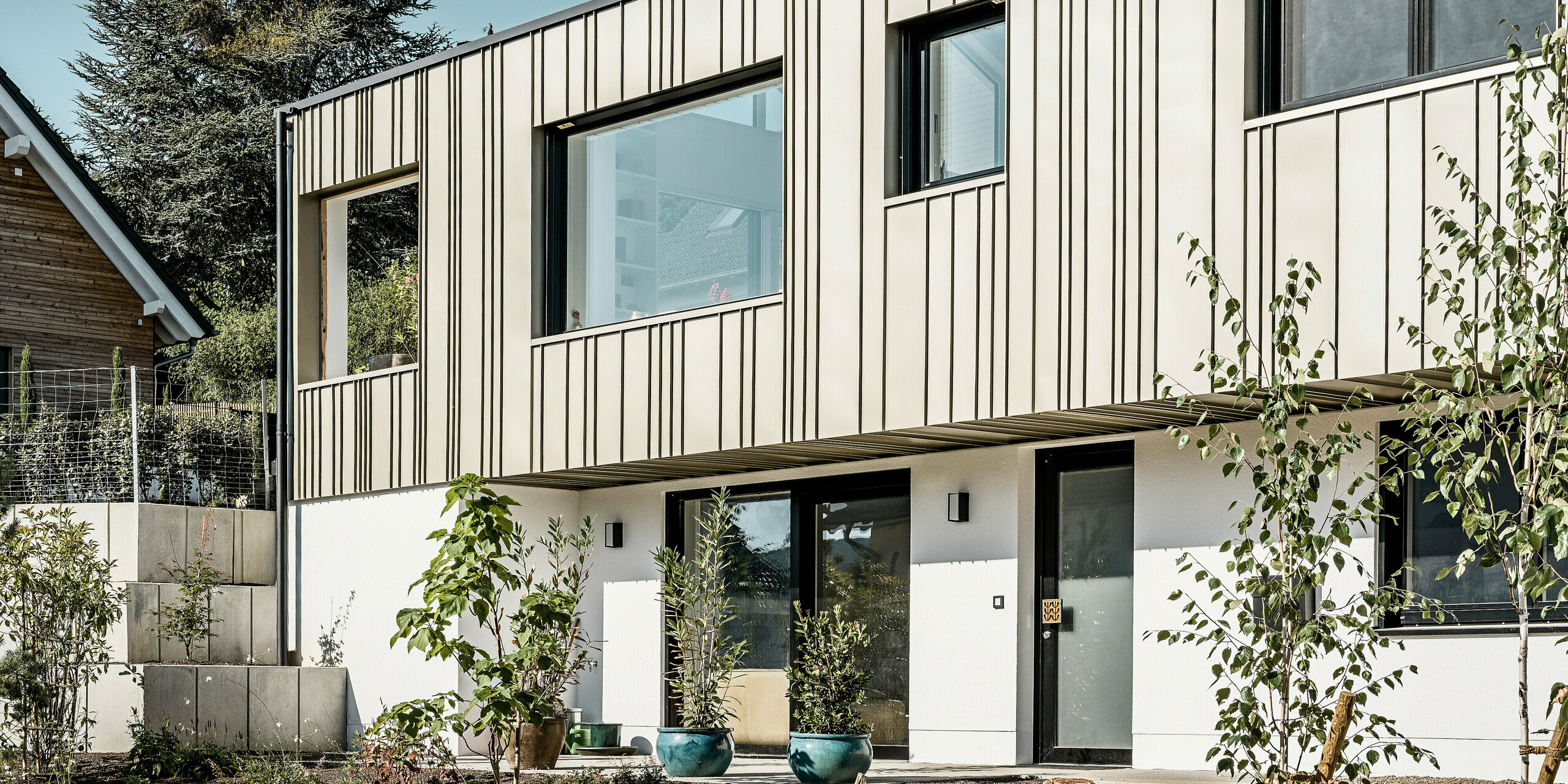 Ein Neubau in Bad Münstereifel wurde eingedeckt mit der PREFA Dachplatte R.16 in anthrazit. Auf dem Dach befindet sich eine Photovoltaik-Anlage. Die Winkelfalzfassade besteht aus Falzonal in lichtbronze.